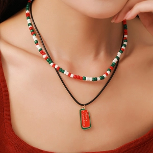 Close-up of a double-layered Christmas beaded necklace and Santa pendant on a model