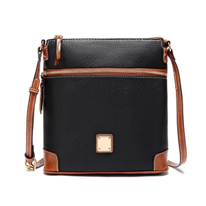 Detail of lychee textured black leather crossbody bag with brown corner accents