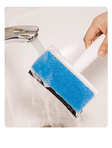 Close-up of dual-purpose glass scraper being rinsed under a faucet over a sink