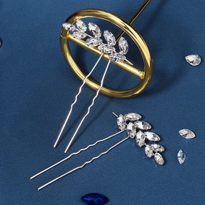 Détail de deux épingles à cheveux argentées en U avec strass marquise sur fond bleu