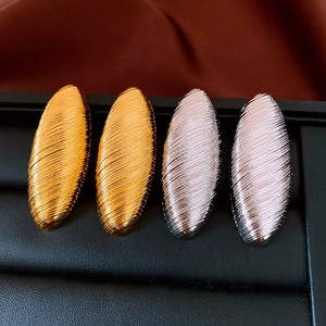 Détails de boucles d'oreilles ovales dorées et argentées à texture de métal brossé