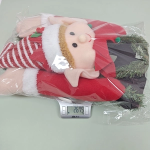 Elf plush tree topper showing product packaging and weight of 267.5g on a digital scale