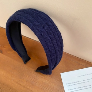 Gros plan détaillé montrant la texture du tissu en maille torsadée bleu marine du bandeau
