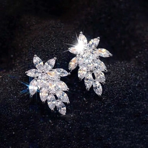 Macro shot of silver marquise-cut crystal leaf stud earrings on a black background