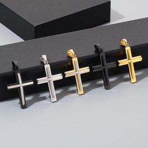 Close-up of cross pendants in black, gold, and silver finishes on a display stand