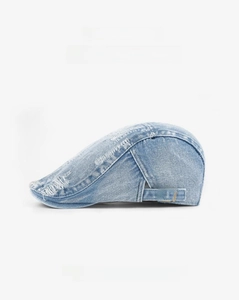 Detail of light blue denim beret showing vintage distressed edges and brass buckle