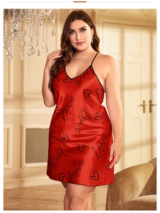 Détail d'une nuisette en satin rouge avec motifs de cœurs noirs et imprimé love
