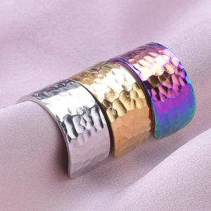 Macro shot of three adjustable stainless steel rings with hammered texture in gold and silver