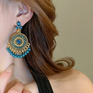 Close-up of Bohemian drop earrings featuring blue rhinestones and turquoise bead tassels