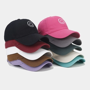 Close-up of smile embroidery on various colored cotton baseball caps with a soft top