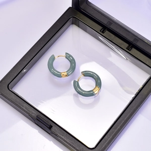 Détail de créoles en émail gris foncé avec fermoir plaqué or 18 carats en présentoir