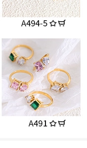 Detailed view of adjustable gold-finish rings with assorted green and pink gemstones