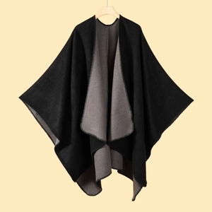 Detailed view of heavy knit black and gray split poncho with stitched hem edges