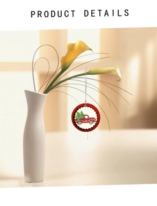 Close-up of red truck Christmas ornament hanging on a calla lily vase for festive decor