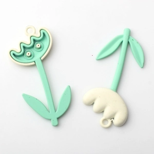 Detailed view of mint green and cream tulip flower charms for DIY jewelry making