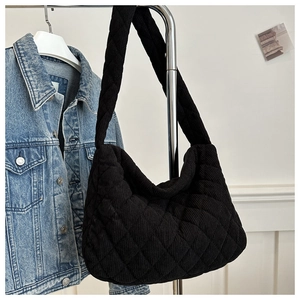 Detailed texture of black corduroy tote bag with diamond quilted embroidery pattern