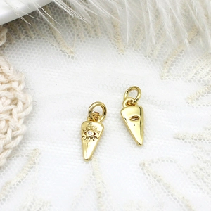Detailed macro view of gold cone pendant with evil eye motif and clear crystal stone
