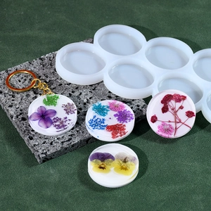 Moule en silicone à 6 cavités circulaires montrant des porte-clés en résine florale