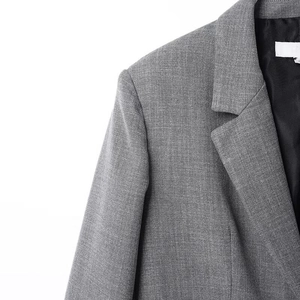Detailed macro view of the grey twill fabric texture and collar on a structured blazer