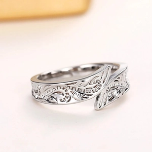 Macro shot of silver feather ring showing dragonfly detail and vintage leaf texture