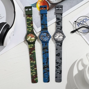 Camo pattern quartz watches for kids in green, blue, and grey on a white desk