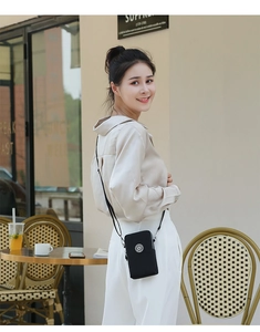 Photo lifestyle d'un mini sac de téléphone noir en nylon sur une tenue élégante
