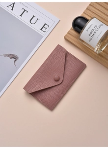 Flat lay of a dusty pink lychee texture envelope card holder with button closure