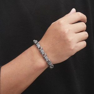 Close-up of retro dragon scale texture on stainless steel bracelet worn on male wrist