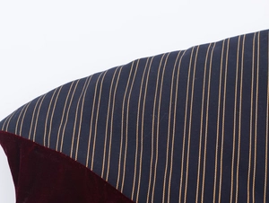 Close-up of navy blue pinstripe fabric and deep red velvet texture on padded vest