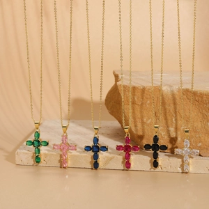 Detail view of gold cross pendants featuring vibrant zircon gemstones in six colors