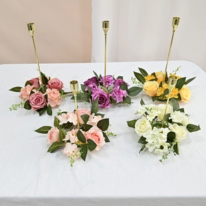 Detail view of colorful artificial rose candle rings on elegant golden metal holders