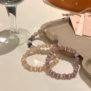 Dettaglio di bracciali con perline occhio di gatto lavanda e rosa con sfere d'argento cave