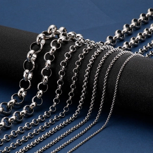 Silver stainless steel rolo and cable chain necklaces displayed on a dark cylinder stand
