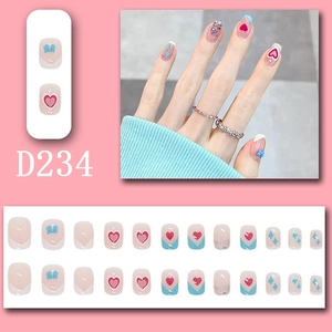 Macro shot of French press-on nails set D234 with pink hearts and blue bows on pink backdrop
