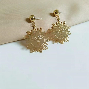 Chic golden sun face drop earrings featuring a bold metallic design for women