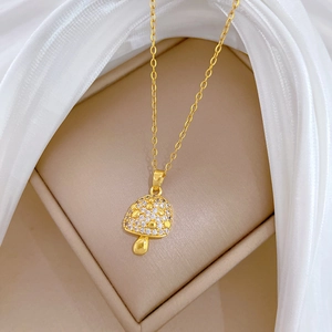 Luxurious gold mushroom pendant necklace with sparkling crystals on elegant beige display