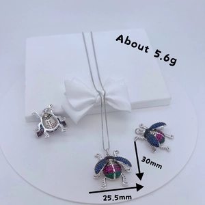 Silver-tone micro-pave insect jewelry set with multi-color gemstones on gift box display