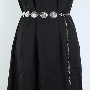 Detail of silver bohemian metal waist chain with round floral carved charms and adjustable clasp