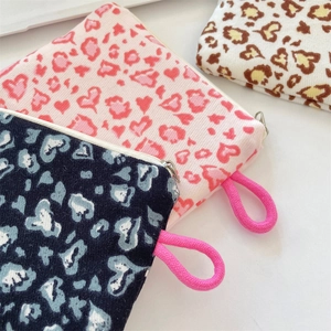 Close-up of knit heart pattern pouches with metal zippers and pink cord handles