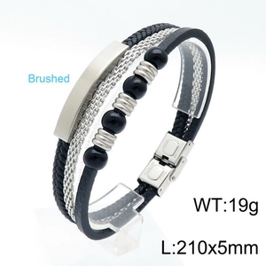 Detailed macro view of brushed stainless steel magnetic clasp on braided leather bracelet