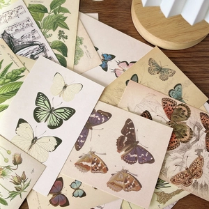 Vintage forest botanical cards with butterflies and plants on a dark wooden table