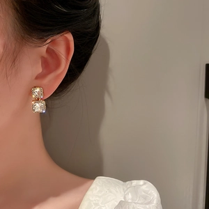Elegant gold double square earrings with clear crystals shown on a model