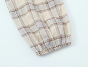 Detailed macro shot of elastic cuff on a checkered long-sleeve blouse in beige and blue
