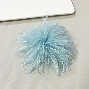 Close-up of fluffy light blue ostrich feather brooch with soft texture on grey fabric
