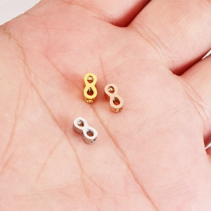 Ciondoli a forma di infinito in acciaio inossidabile oro, oro rosa e argento su palmo