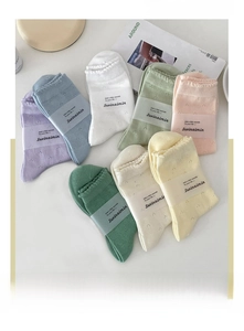 Flat lay of macaron-colored lace socks featuring heart-shaped hollow knit and ruffled cuffs