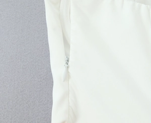 Détail d'une robe corset blanche montrant la fermeture éclair invisible haut de gamme