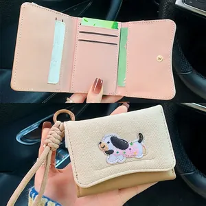 Three-fold beige dachshund patch wallet with pink interior and woven wrist strap