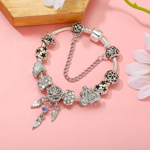 Detail of silver-plated charm bracelet with pumpkin carriage and tree of life charms