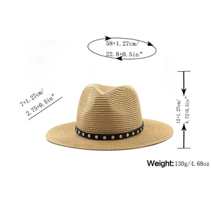 Close-up of woven straw fedora hat with black leather band and silver studs detailing